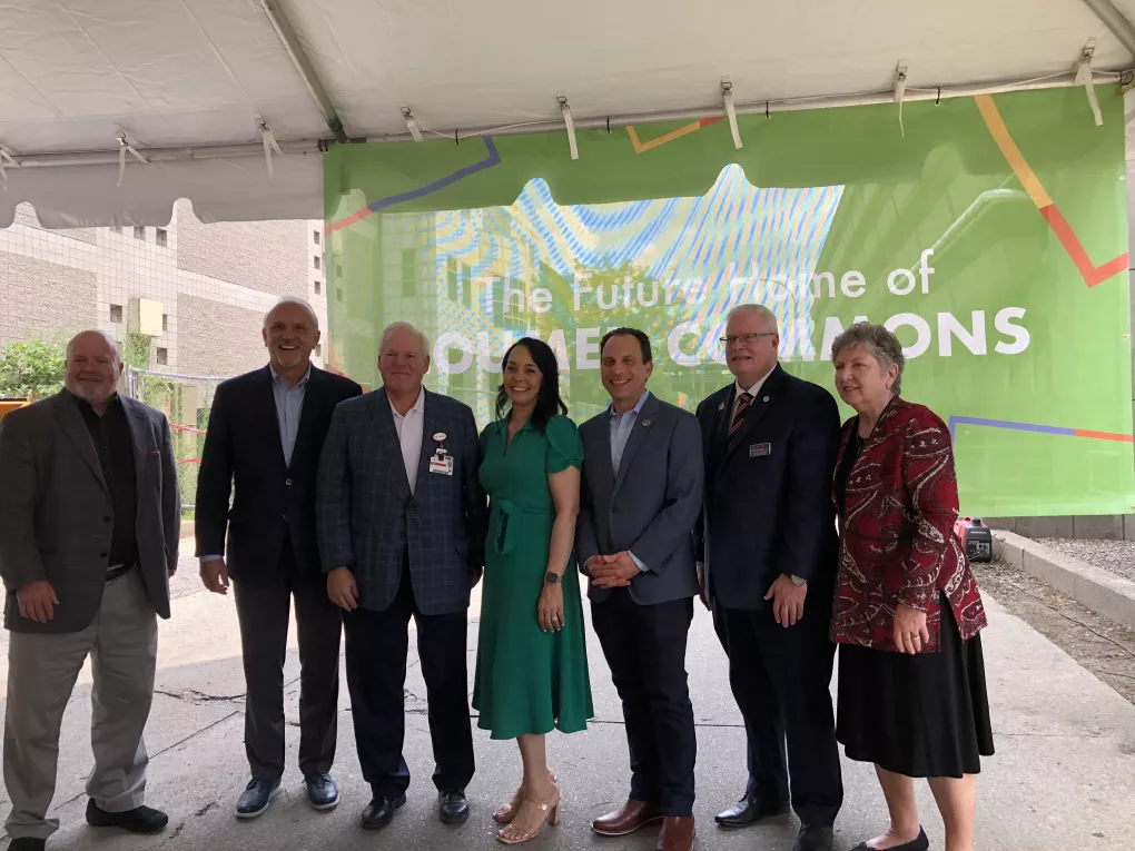 LOUMED and city leaders standing in front of banner for LOUMED Commons.