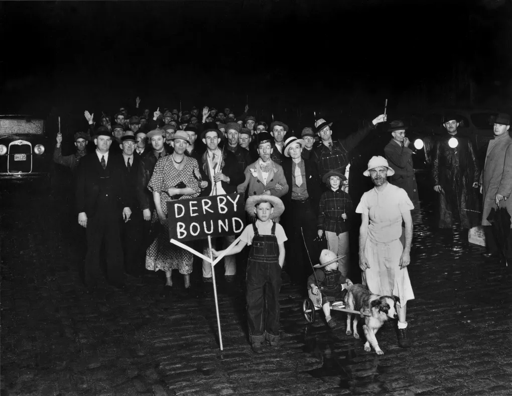 A black and white photo from 1937 of a group of Derby-goers, several in costume, preparing for the race. Caufield & Shook Inc. became the official photographer of the Kentucky Derby in 1924.