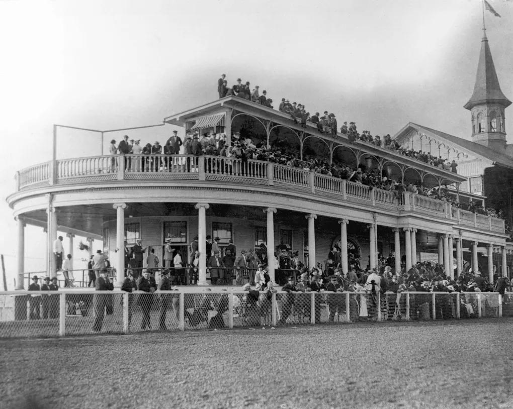 Black and white photograph from 1914 of the old Churchill Downs Clubhouse next to the Twin Spires.