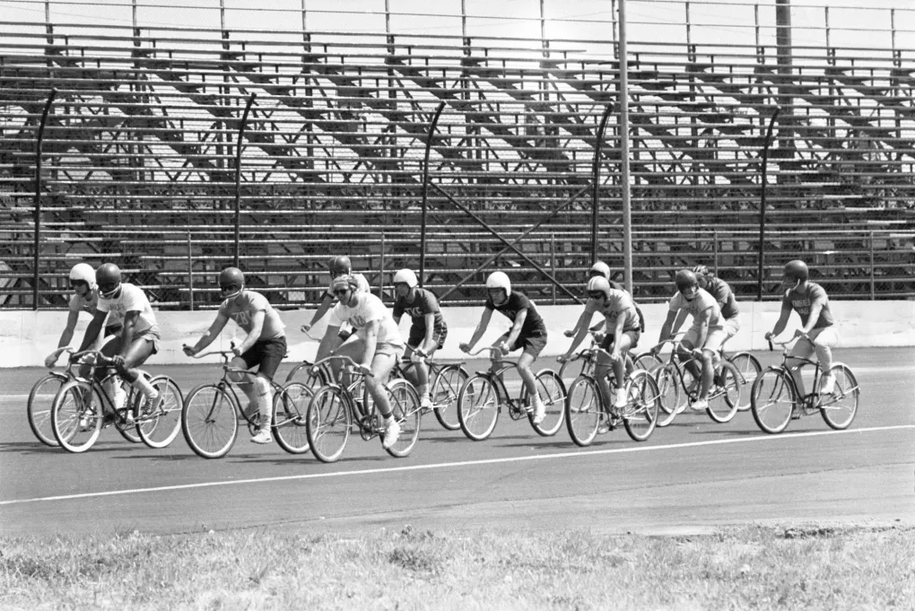 YA black and white photo of a dozen cyclists in helmets at the 1968 Pegasus Pedalathon, a bicycle/tricycle racing competition among UofL’s fraternities, sororities and student groups.