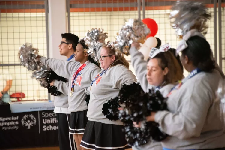 Group of cheerleaders wave pom-poms