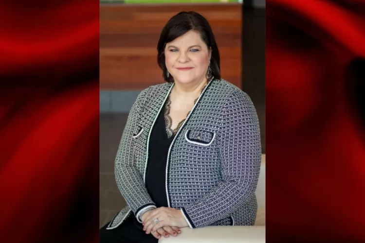 Woman in black and white jacket poses for photo.