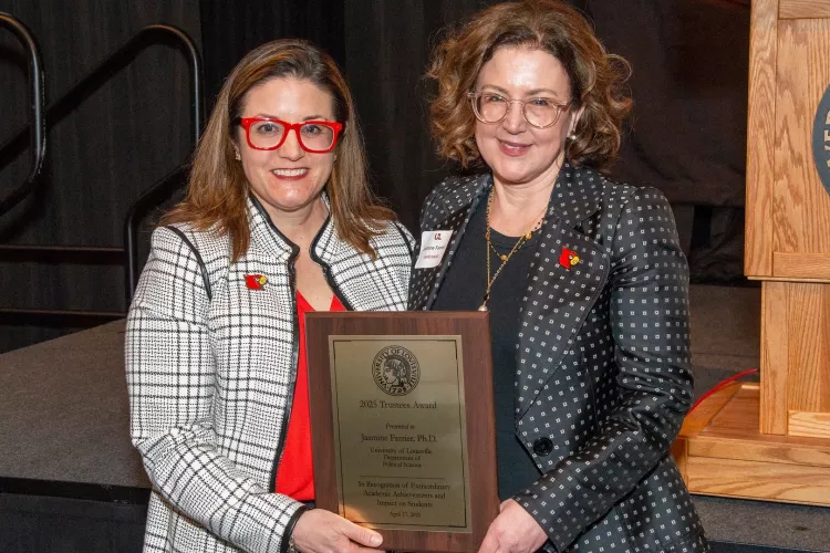 Jasmine Farrier, right, is presented with the 2025 UofL Trustees Award at the 2025 UofL Presidential Excellence Awards reception, which took place April 17, 2025. Pictured with Farrier is UofL Interim Provost Katie Cardarelli.