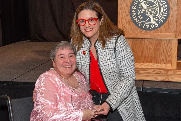 Linda Leake, left, receives the George J. Howe Distinguished Staff Award from University of Louisville Interim Provost Katie Cardarelli at UofL's 2025 Presidential Excellence Awards reception on April 17, 2025.