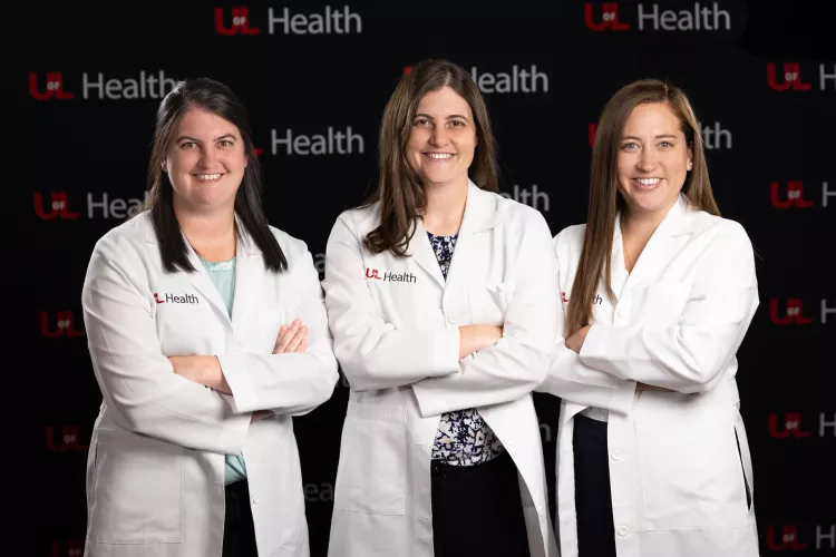 Allison, Lauren and Stephanie Boden smiling for the camera in their white doctor coats.