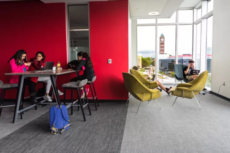 Students studying in the BACB with the clocktower and campus in the background