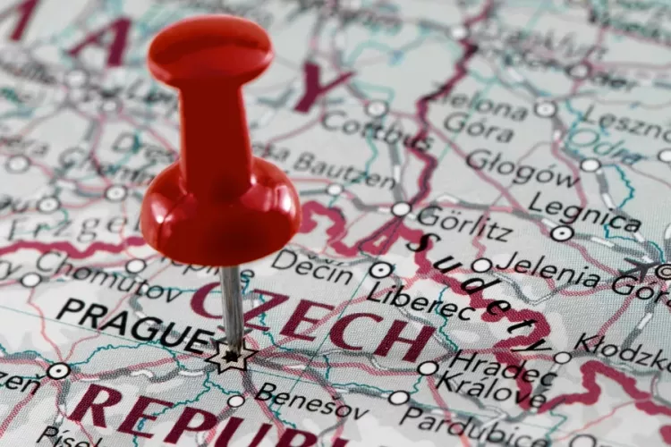 A red thumbtack pinned on an international map of the world.