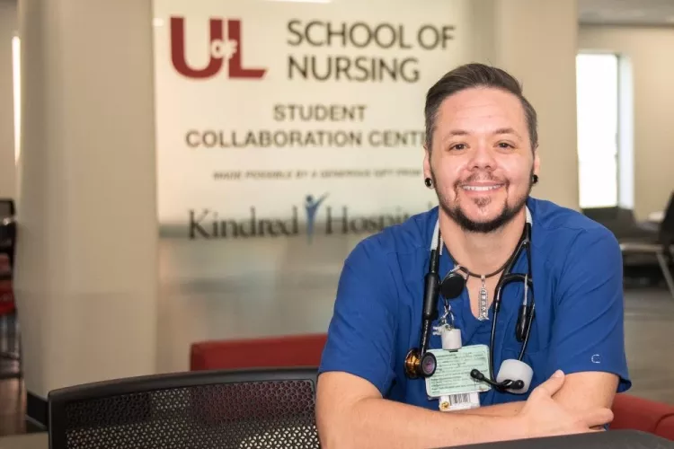 Nursing student posing in front of School of Nursing building