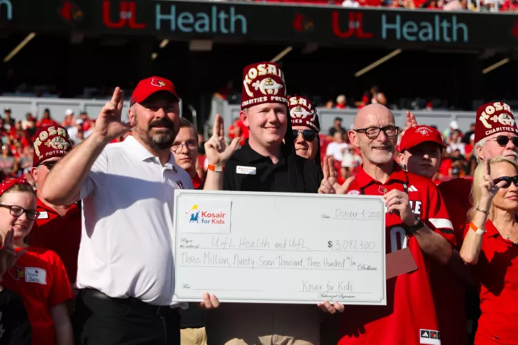 Gerry Bradley and Jason Smith hold a Kosair for Kids check at the Oct. 4 UofL football game.