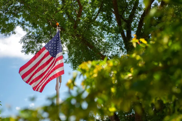 American flag waving in the wind on Belknap Campus