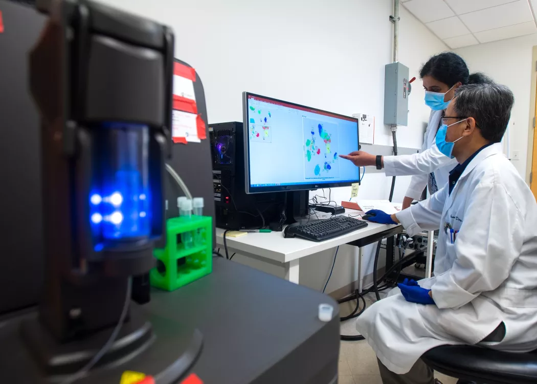 Kavitha Yaddanapuddi, Ph.D., and Chuanlin Ding, Ph.D., use a mass cytometer to help improve the effectiveness of cancer immunotherapies.