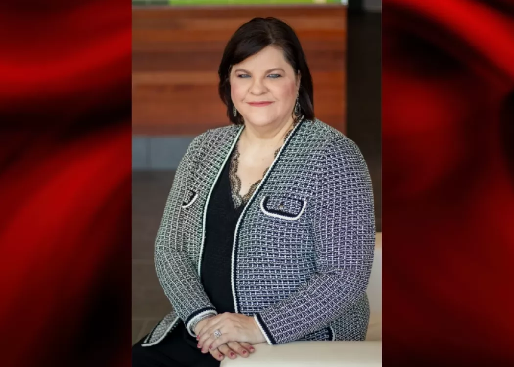 Woman in black and white jacket poses for photo.