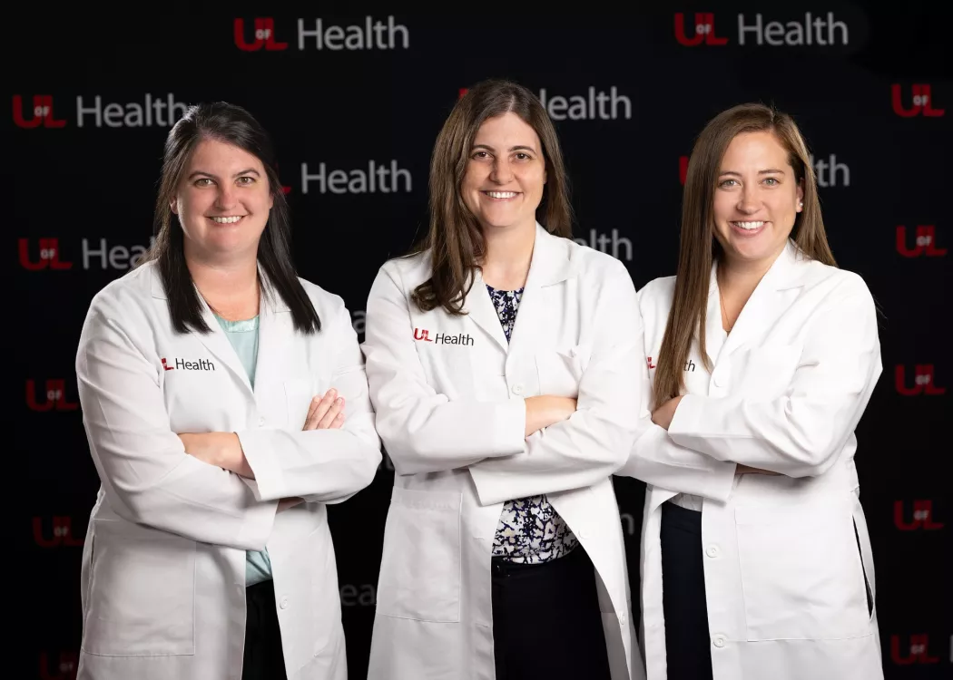 Allison, Lauren and Stephanie Boden smiling for the camera in their white doctor coats.