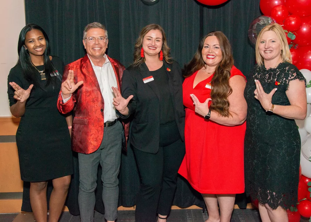 Leaders from UofL's Employee Success Center celebrate together by throwing their L's up., Five leaders from UofL's Employee Success Center throw their L's up in a posed photo.