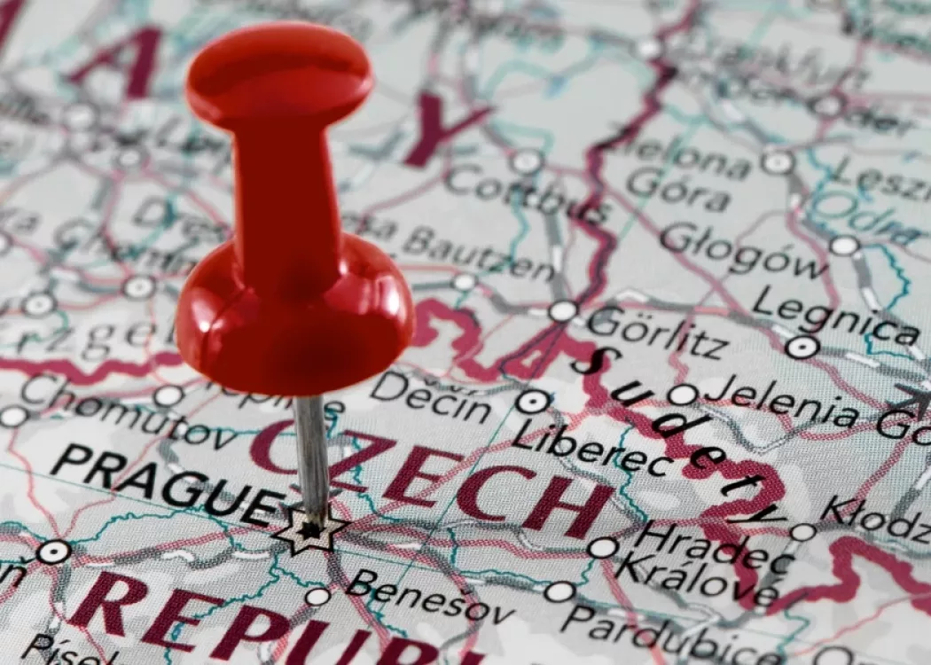 A red thumbtack pinned on an international map of the world.