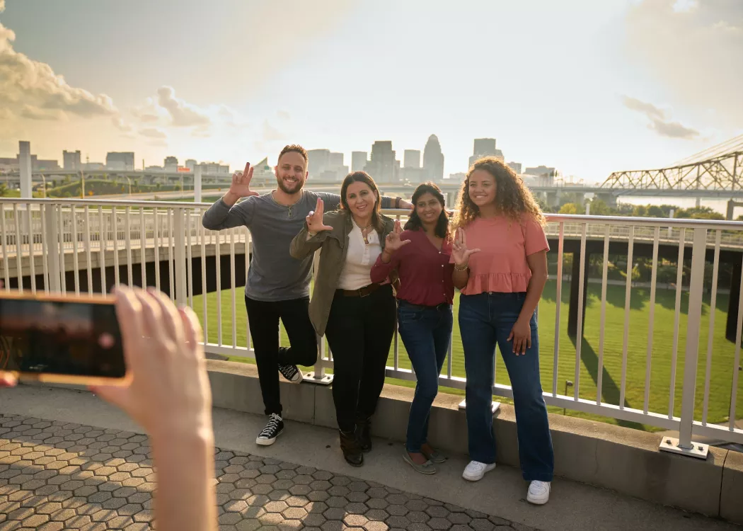 Students throwing up their L's for a group photo opportunity at the Big Four Bridge at Waterfront Park in downtown…