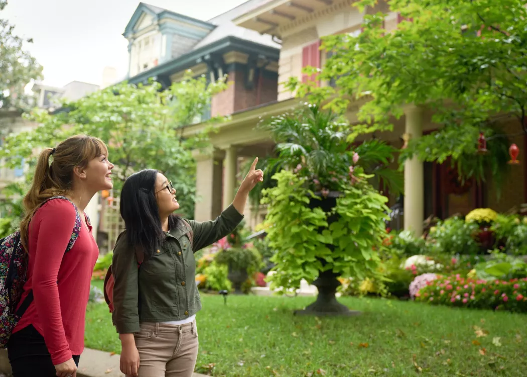 Two students walking through the Old Louisville neighborhood, looking at houses.