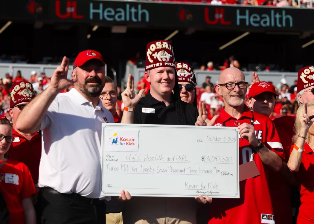 Gerry Bradley and Jason Smith hold a Kosair for Kids check at the Oct. 4 UofL football game.