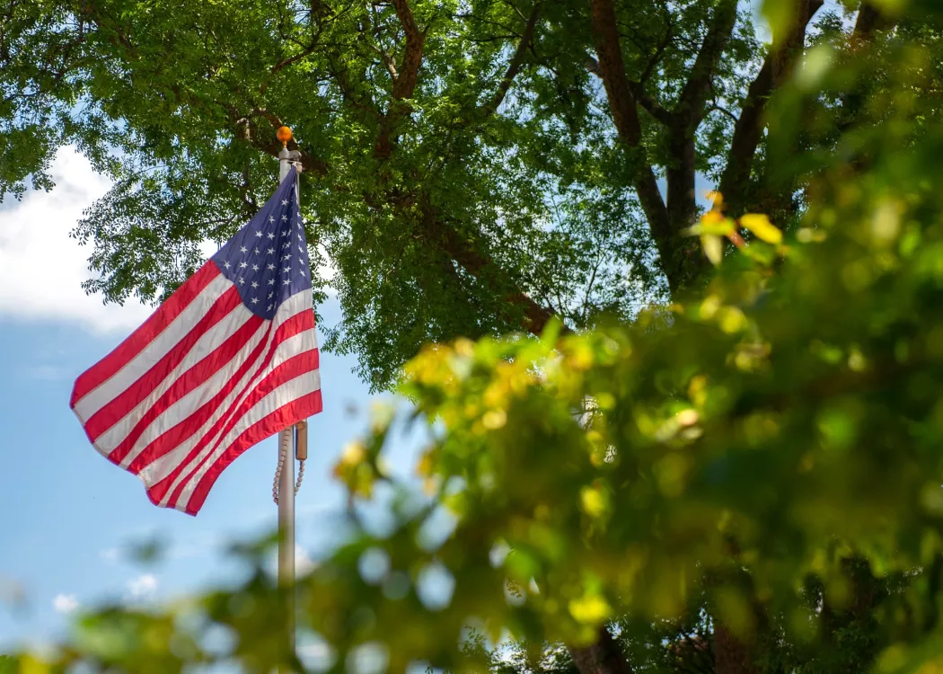 American flag waving in the wind on Belknap Campus
