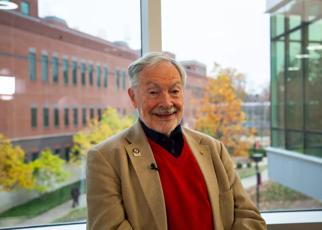 Man in red vest inside UofL building