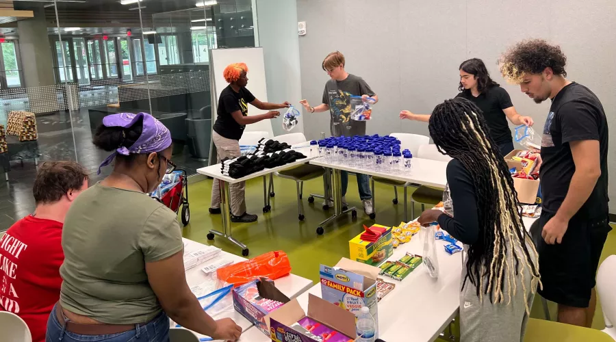 UofL students sort food and other donations at a table.