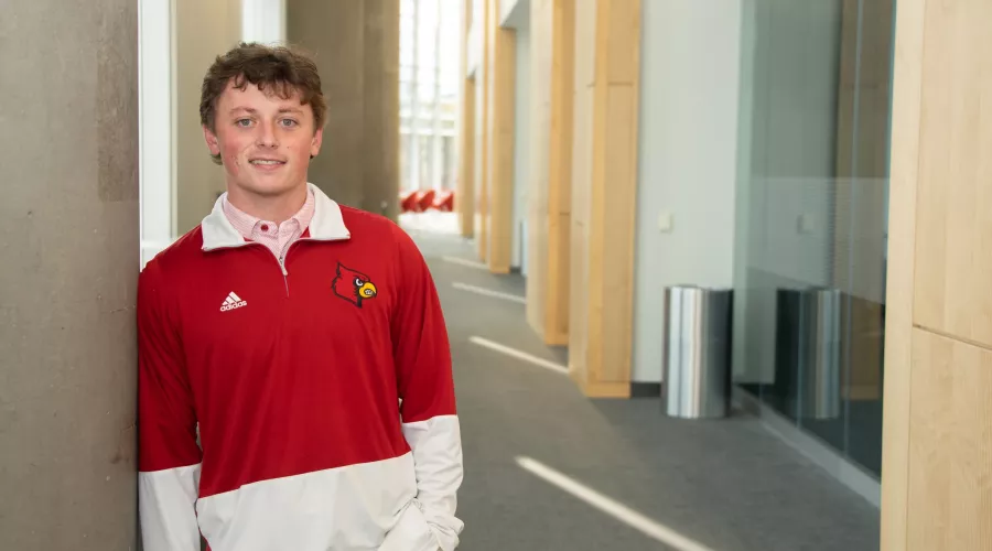 James Walls smiles will wearing a UofL sweatshirt