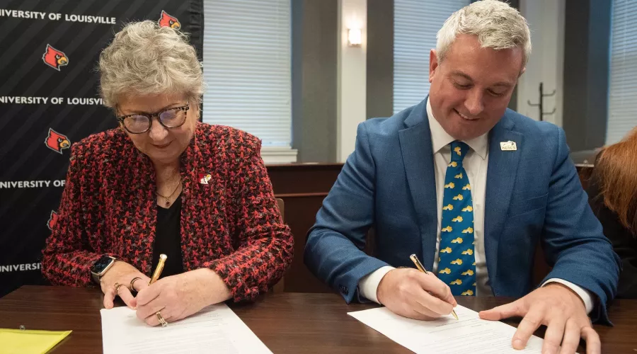 UofL President Kim Schatzel and KCTCS president Ryan Quarles sign an expanded transfer agreement on Dec. 9, 2024.
