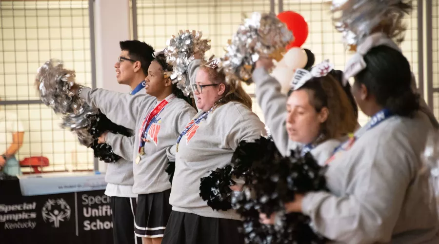 Group of cheerleaders wave pom-poms