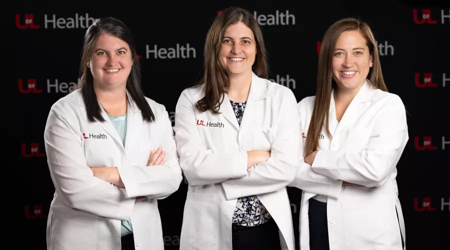 Allison, Lauren and Stephanie Boden smiling for the camera in their white doctor coats.