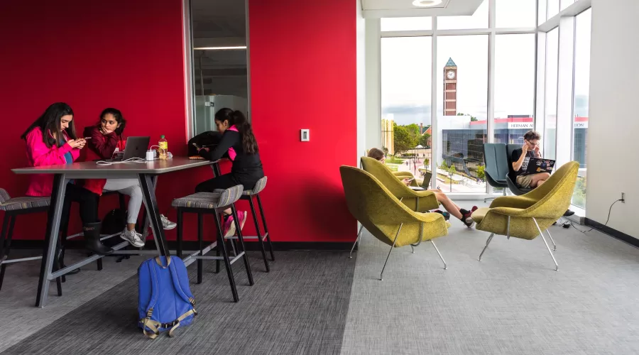 Students studying in the BACB with the clocktower and campus in the background