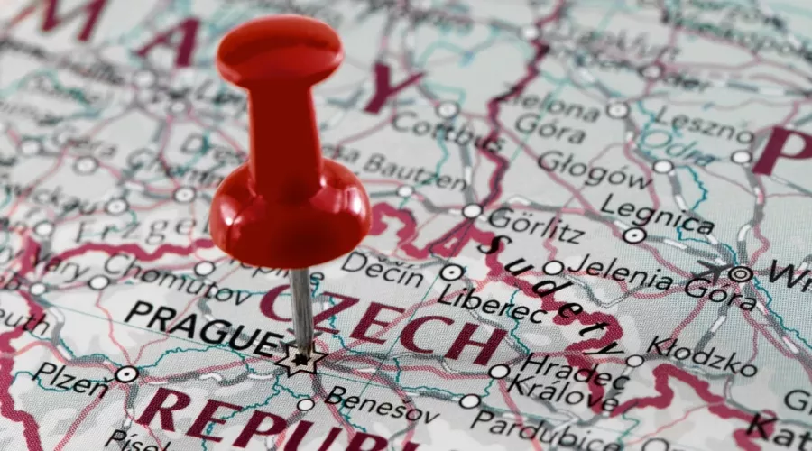 A red thumbtack pinned on an international map of the world.