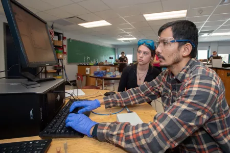 A student types into a computer as data appears