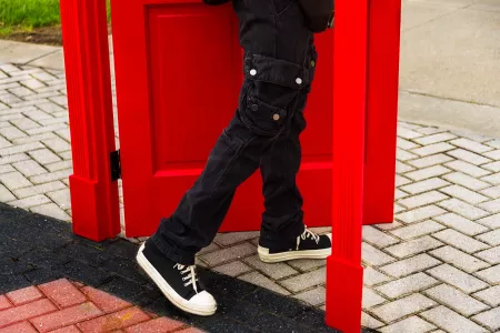 Student walking through a red door in the middle of campus