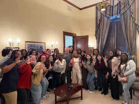 A group of college students pose with Senator Mitch McConnell in his office.