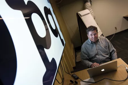 Steve Skaggs, '73 in front of a laptop