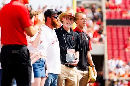 UofL President Gerry Bradley and his son on a college football field.