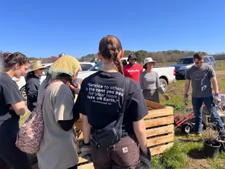 A group of students doing community service outdoors in Virginia Beach.