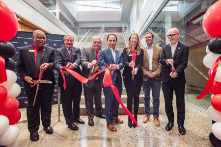 A group of political leaders from Kentucky cut a red ribbon to open the new Speed School building.